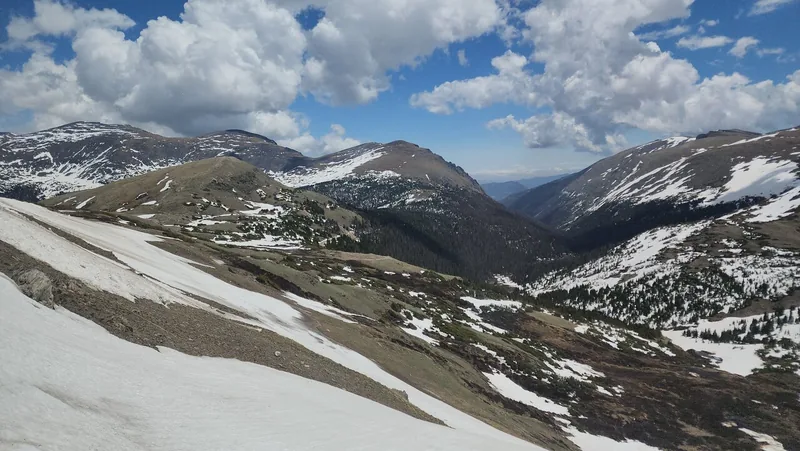 Snowfields and tundra slopes above a deep valley on Trail Ridge Road